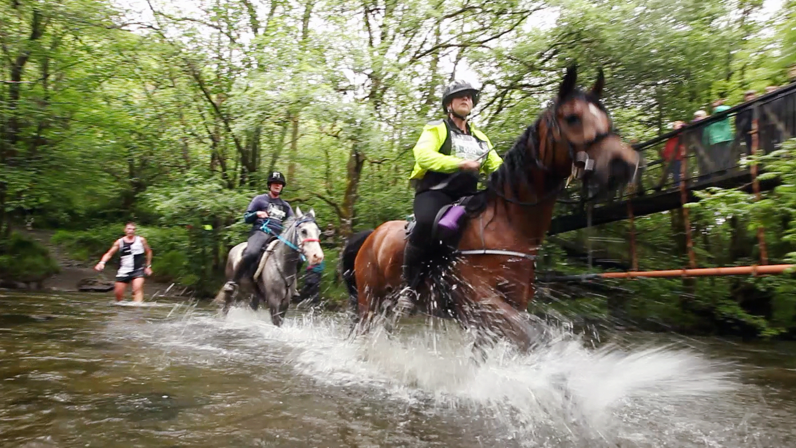 Horses and runners charging through river crossing