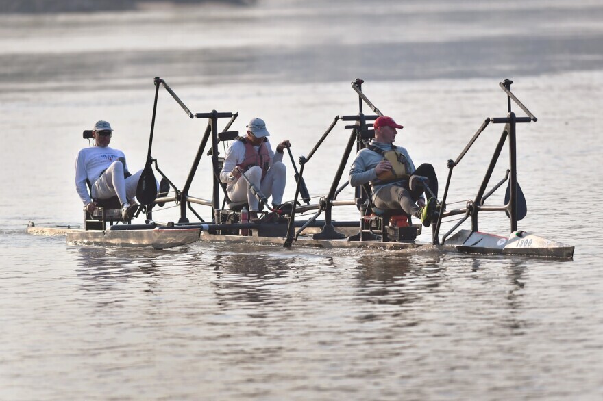 Men operating traditional boats on the Missouri River